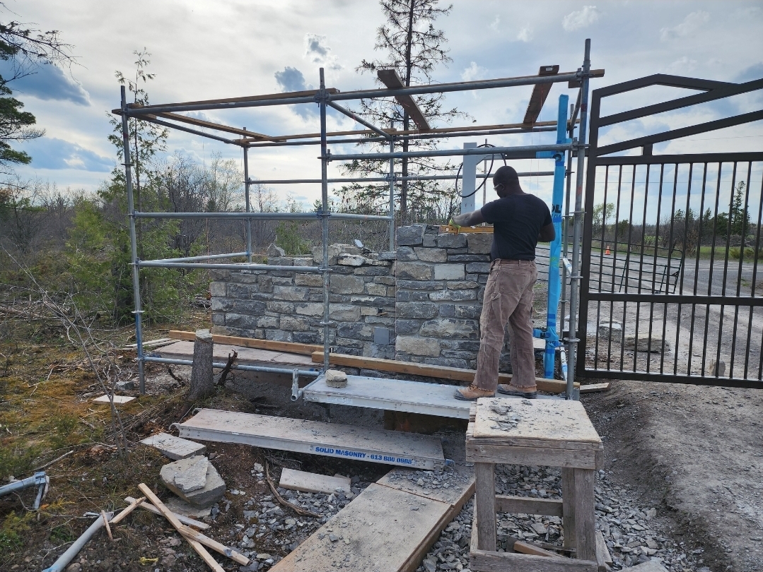Garvin Louisy building a natural-stone entrance wall